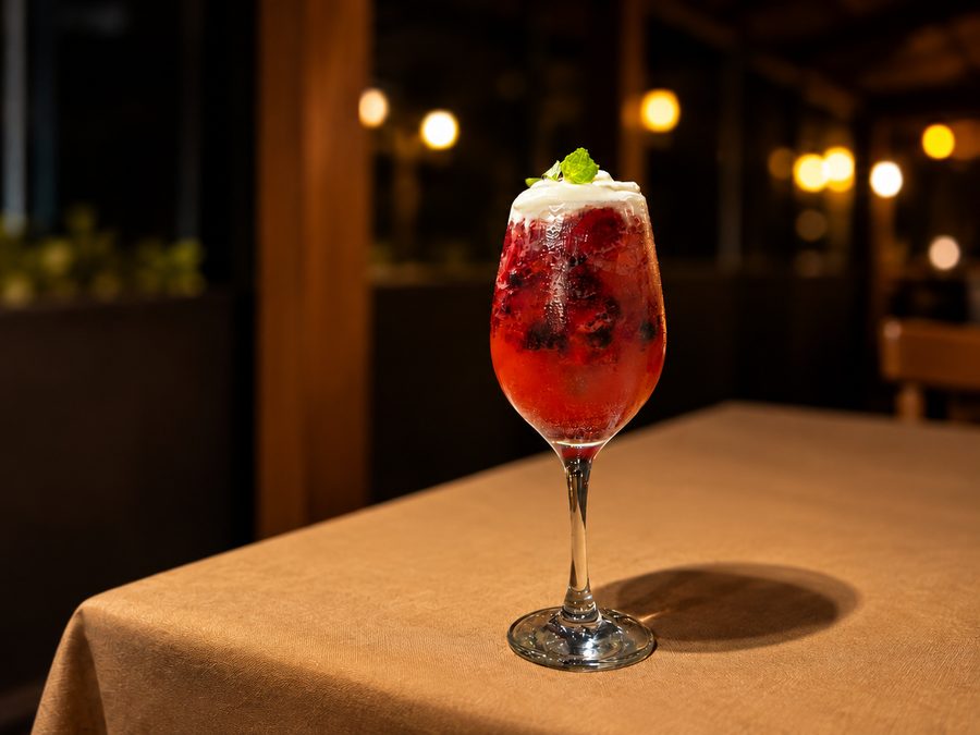 Aline's Drink em taça com frutas vermelhas, espuma e hortelã